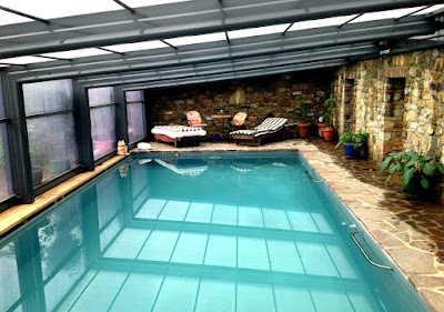 Una piscina con cubierta en el jardín